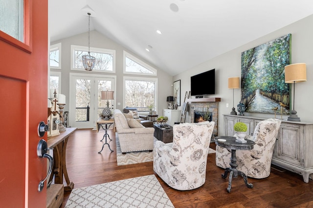 living room featuring high vaulted ceiling, dark wood-style flooring, and a fireplace