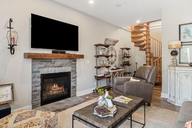 living room with baseboards, stairway, wood finished floors, a fireplace, and recessed lighting