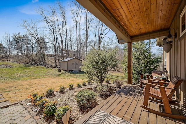 wooden terrace featuring a storage unit, a lawn, and an outdoor structure