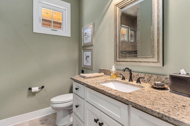 full bathroom with toilet, vanity, tiled shower, baseboards, and tile patterned floors