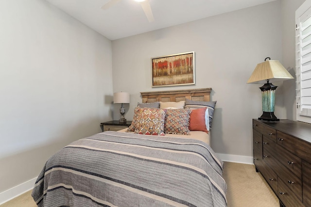 bedroom with a ceiling fan, light colored carpet, and baseboards