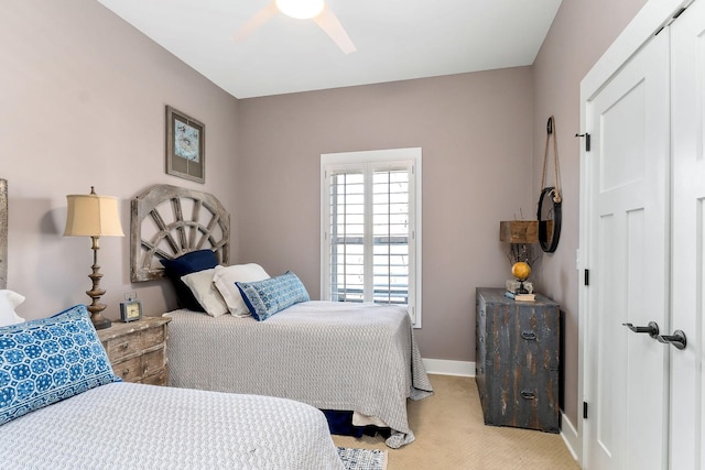 bedroom featuring light carpet, ceiling fan, and baseboards