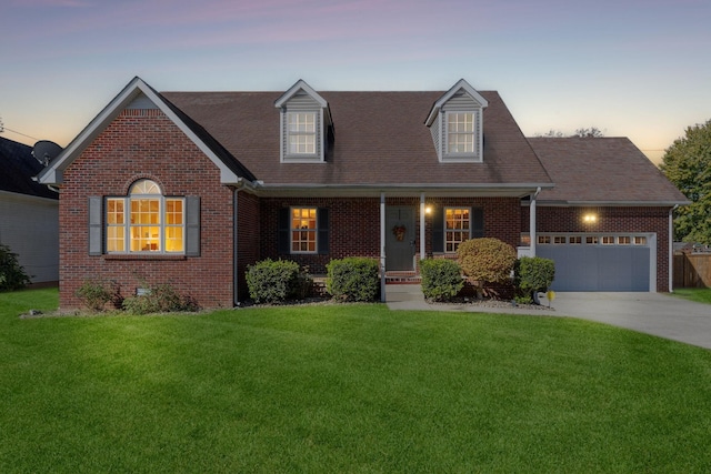 cape cod-style house featuring an attached garage, a front lawn, concrete driveway, and brick siding