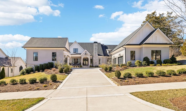 modern farmhouse with driveway, board and batten siding, and a front yard