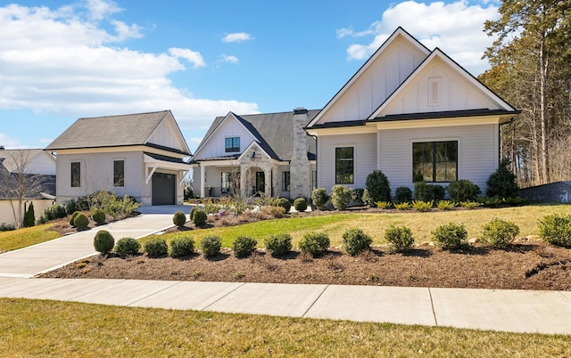 modern farmhouse featuring an attached garage, a front lawn, board and batten siding, and concrete driveway