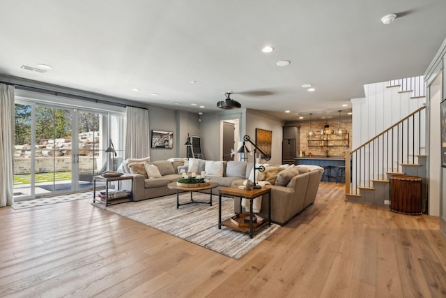 living area featuring light wood finished floors, visible vents, stairway, and recessed lighting