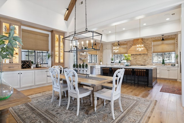 dining room with high vaulted ceiling, light wood-style flooring, recessed lighting, visible vents, and crown molding