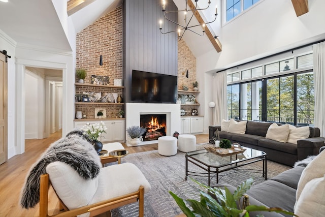 living room with a lit fireplace, plenty of natural light, high vaulted ceiling, and light wood-style flooring