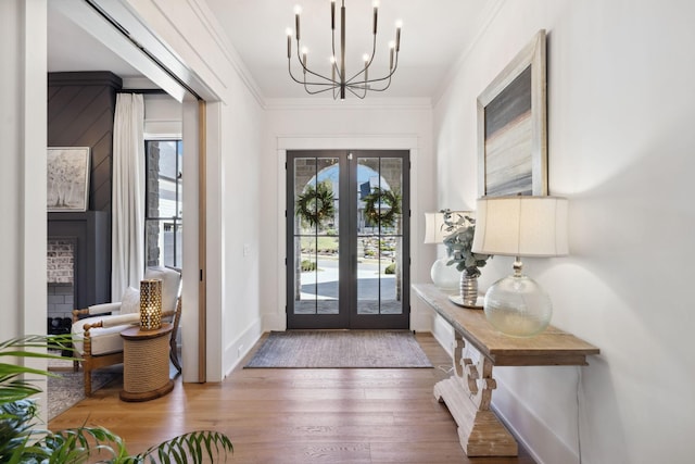 entryway featuring ornamental molding, wood finished floors, a wealth of natural light, and french doors