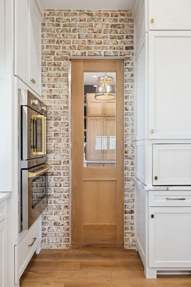 interior space with brick wall and light wood-style floors