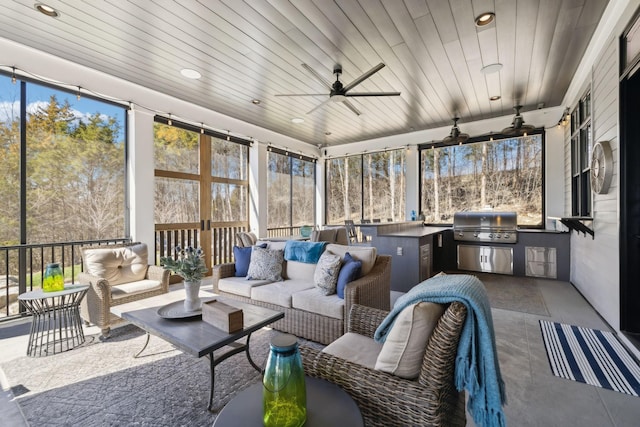 sunroom / solarium featuring ceiling fan, wooden ceiling, and a wealth of natural light