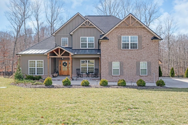 view of front of house with a front lawn, a standing seam roof, board and batten siding, and brick siding