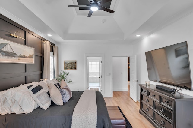 bedroom featuring ceiling fan, a tray ceiling, recessed lighting, and light wood-style floors