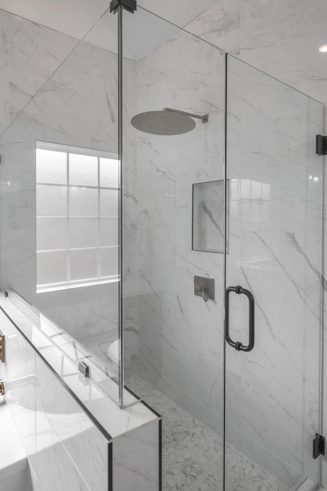 full bathroom featuring a marble finish shower