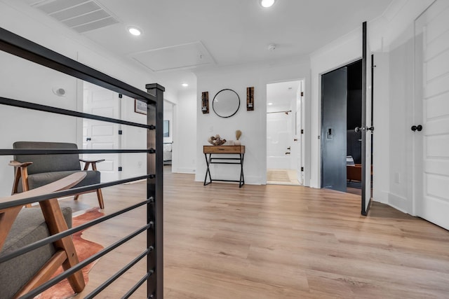 corridor featuring ornamental molding, light wood finished floors, visible vents, and recessed lighting