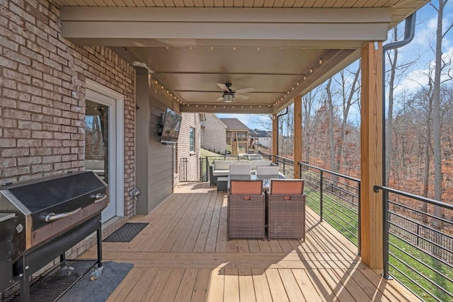 wooden terrace featuring ceiling fan, outdoor dining space, and grilling area