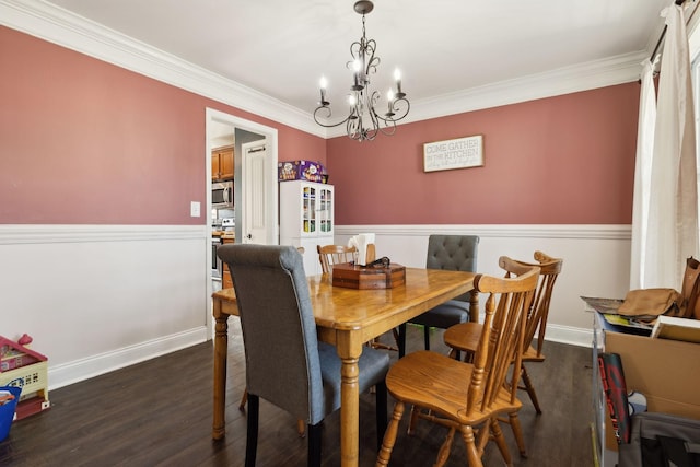 dining area featuring a notable chandelier, dark wood-type flooring, baseboards, and crown molding