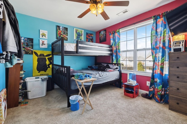 carpeted bedroom with visible vents and a ceiling fan