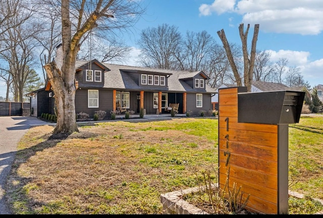 view of front of home featuring covered porch and a front lawn