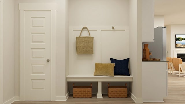 mudroom featuring a fireplace and wood finished floors