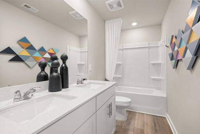 full bathroom with toilet, wood finished floors, a sink, and visible vents