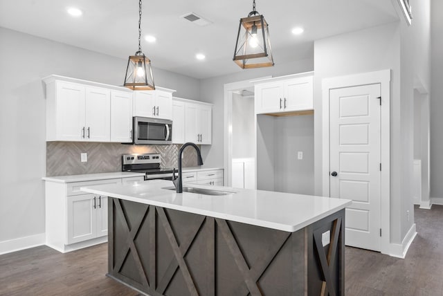 kitchen featuring dark wood finished floors, visible vents, backsplash, appliances with stainless steel finishes, and a sink