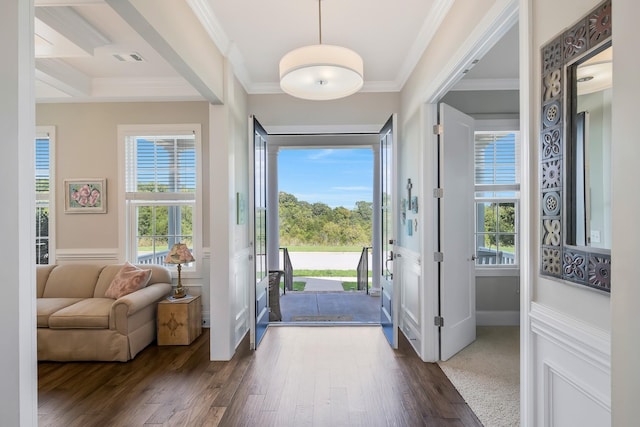 entrance foyer featuring dark wood-style floors, ornamental molding, wainscoting, and visible vents