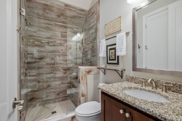 full bath with a stall shower, vanity, and toilet