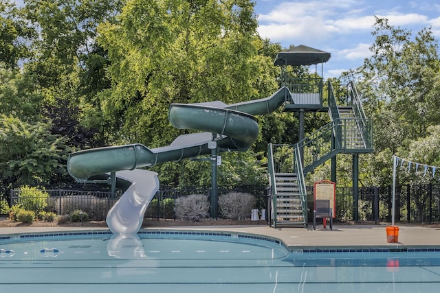 exterior space with a water slide, stairway, and fence