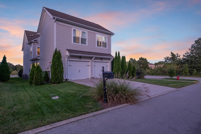 traditional-style house with an attached garage, central AC unit, a front lawn, and concrete driveway