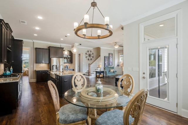 dining room featuring ornamental molding, a wealth of natural light, visible vents, and dark wood-type flooring