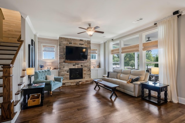 living room featuring a wealth of natural light, dark wood-style flooring, visible vents, and stairway