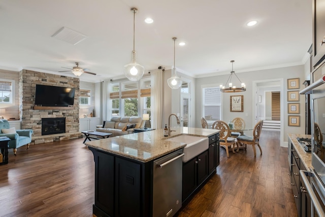 kitchen with a fireplace, a sink, ornamental molding, dishwasher, and dark wood finished floors