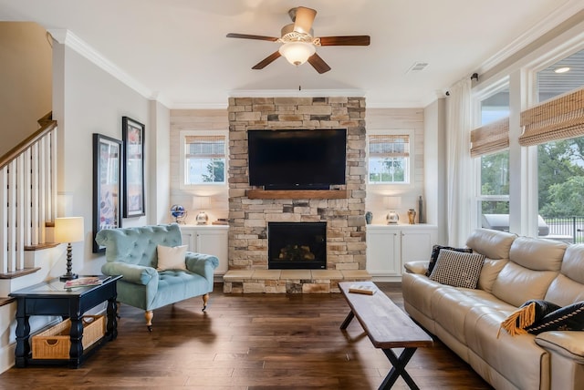 living room with a fireplace, wood finished floors, visible vents, and crown molding