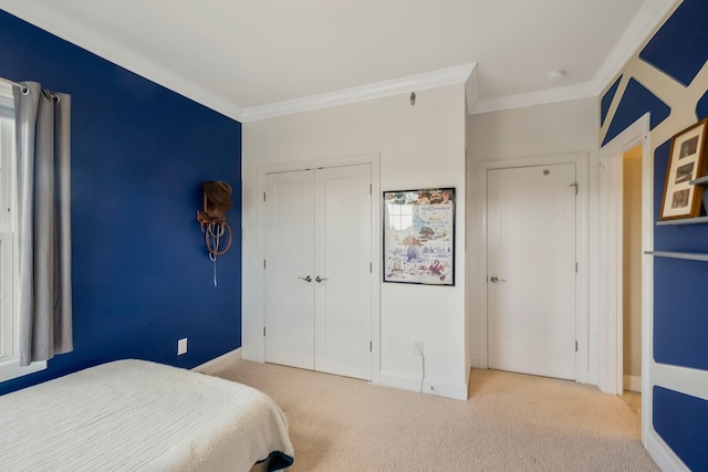 carpeted bedroom featuring baseboards, ornamental molding, and a closet