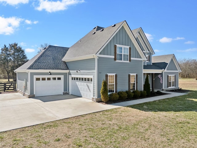 view of front of property featuring board and batten siding, concrete driveway, a front lawn, and an attached garage