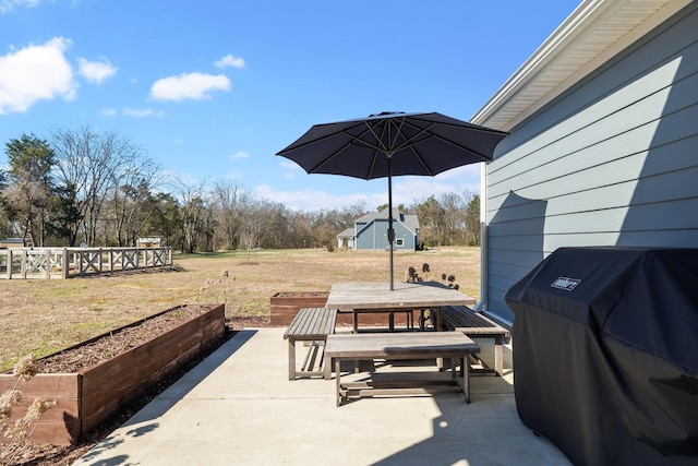 view of patio featuring outdoor dining area, grilling area, and a vegetable garden