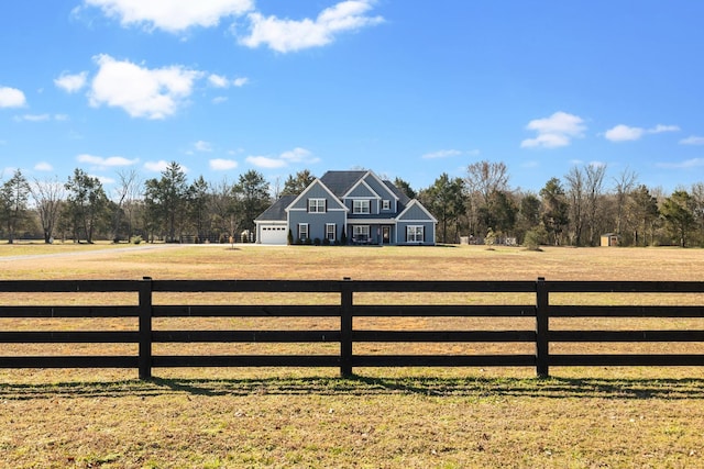 view of gate with a rural view, a yard, and a fenced front yard