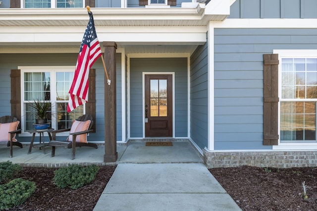 entrance to property with a porch and board and batten siding