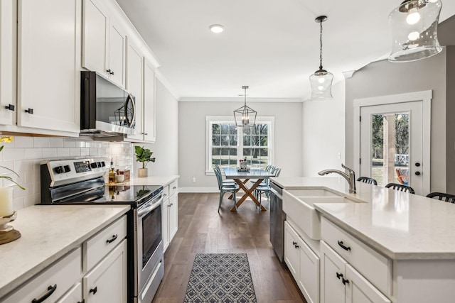 kitchen featuring crown molding, stainless steel appliances, backsplash, dark wood-type flooring, and a sink