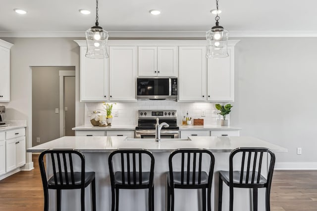 kitchen with a kitchen bar, appliances with stainless steel finishes, and backsplash