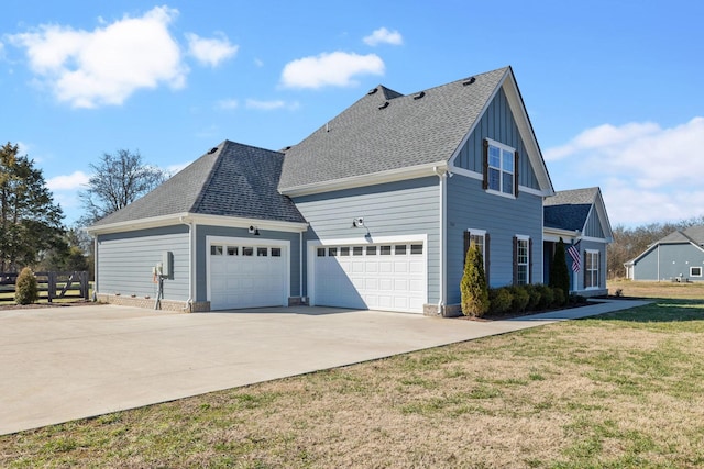 view of side of home with a garage, concrete driveway, roof with shingles, a yard, and board and batten siding