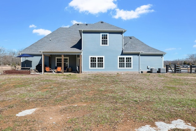 back of house featuring a patio, a lawn, cooling unit, and roof with shingles