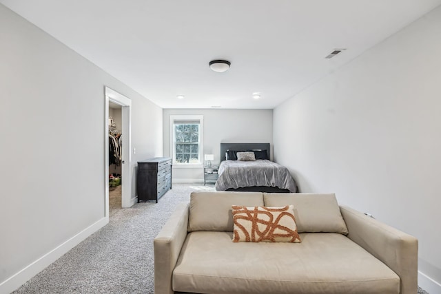 carpeted bedroom with visible vents, a spacious closet, and baseboards