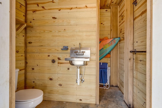 bathroom with wood walls and toilet