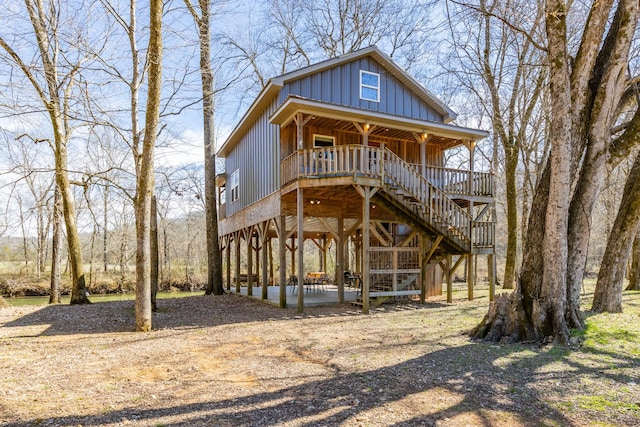 view of front facade with a porch, board and batten siding, and stairway