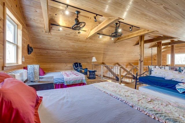 bedroom with lofted ceiling with beams, wood walls, wood ceiling, and rail lighting