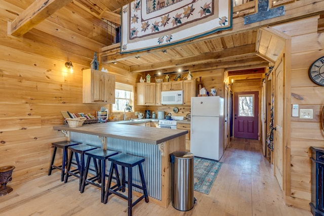 kitchen featuring wooden walls, white appliances, wood ceiling, light brown cabinetry, and beamed ceiling