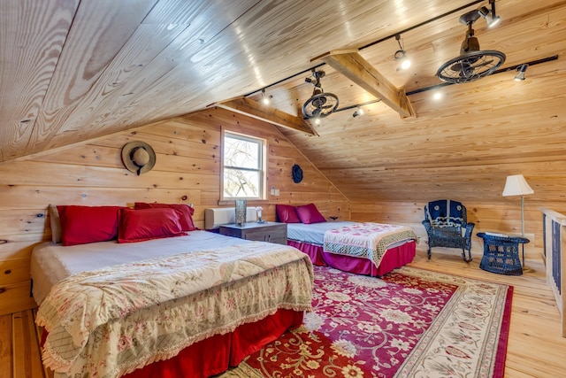 bedroom with vaulted ceiling with beams, wooden ceiling, wood walls, wood finished floors, and rail lighting