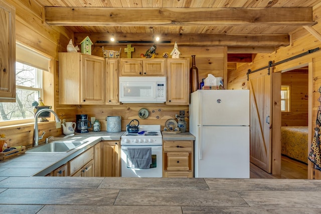 kitchen featuring white appliances, light brown cabinets, a sink, and a barn door